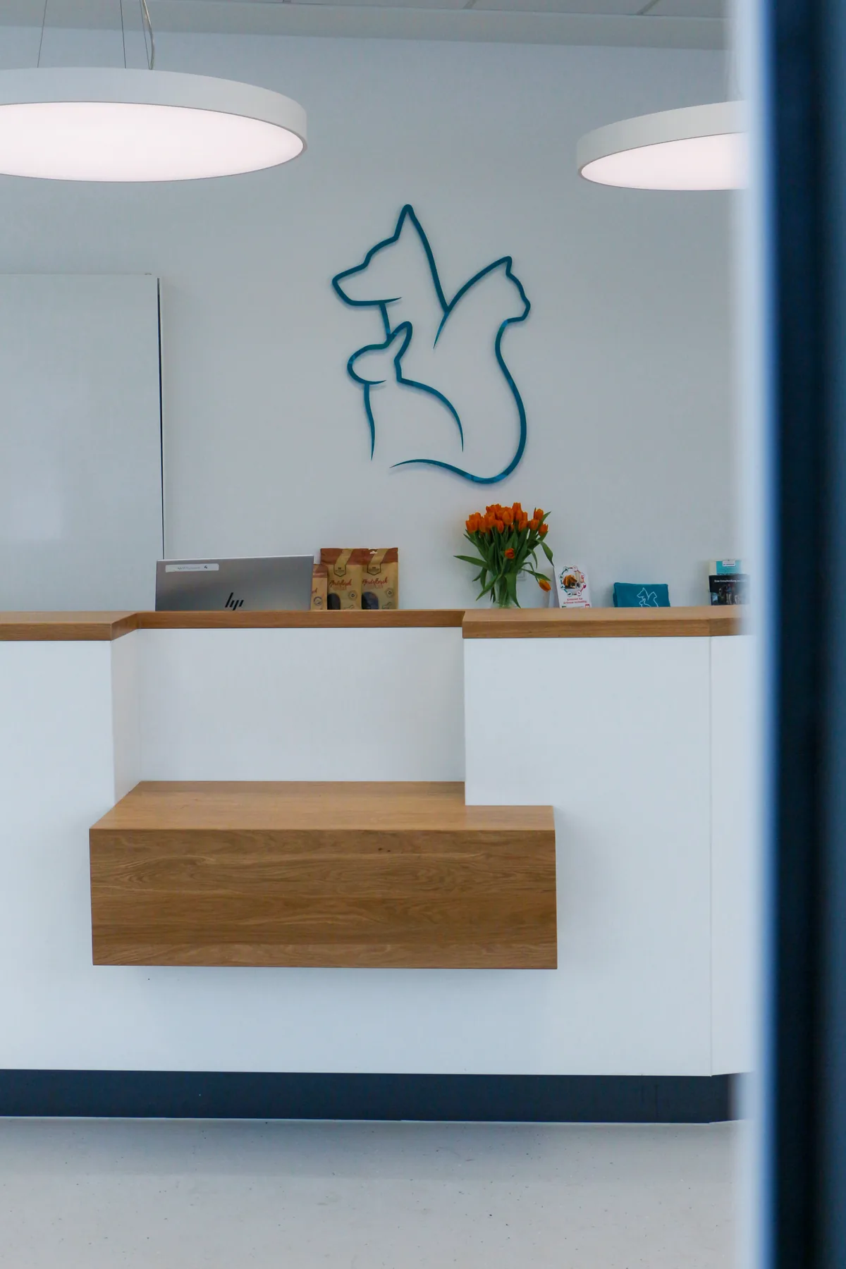 Empfangstresen der Kleintierpraxis Cremlingen mit dem Praxislogo an der Wand.