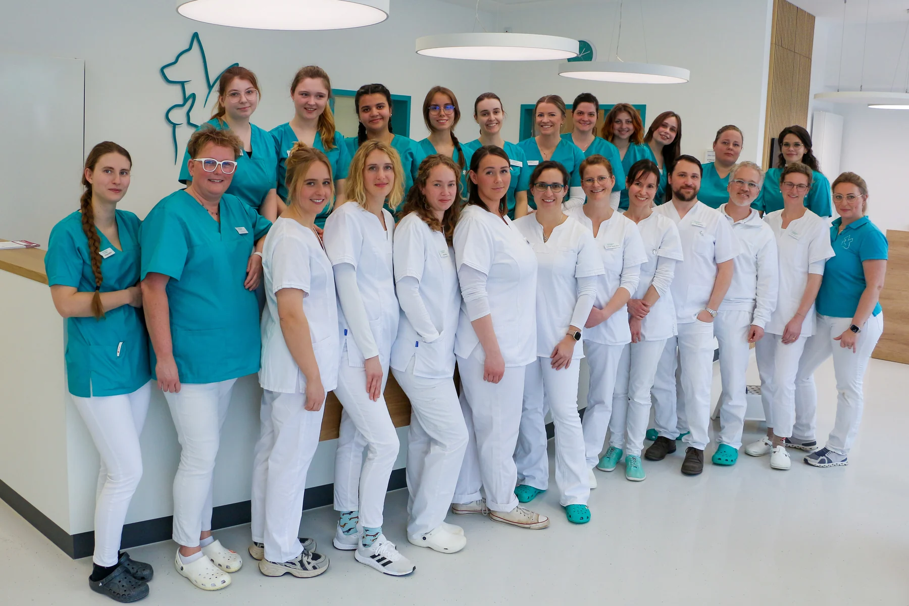The whole team of Kleintierpraxis Cremlingen, around 25 veterinarians and veterinary nurses in the bright reception area.