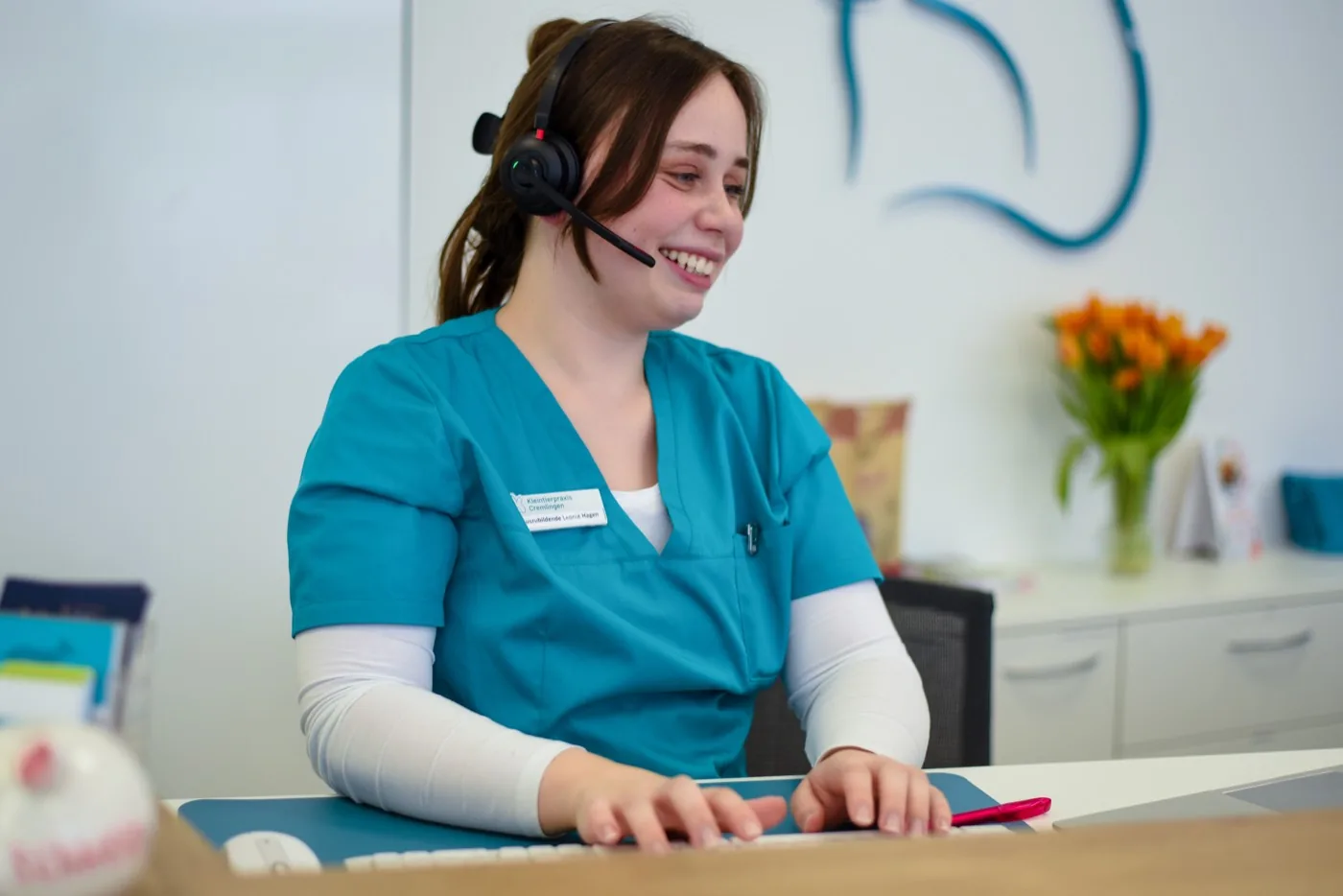 A member of staff at Kleintierpraxis Cremlingen taking a call at reception and coordinating care.