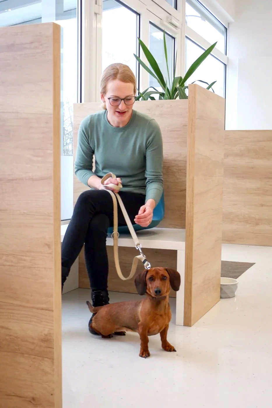 Dog owner with her dachshund in one of the quiet wooden waiting booths.
